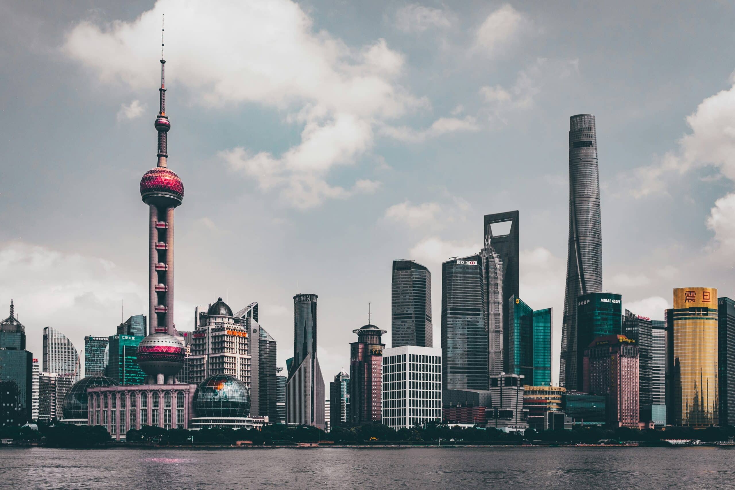 Stadtaufnahme über den Fluss hinweg von Shanghai bei wolkenbedecktem Himmel