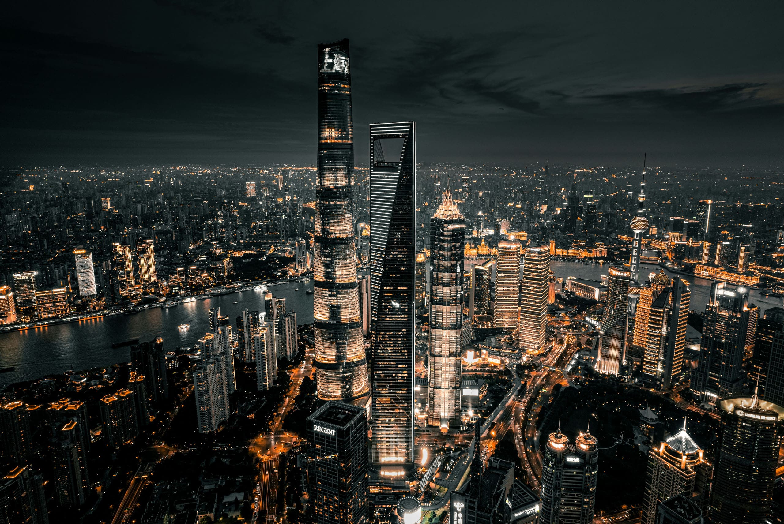 Ein großflächiges Panoramabild von Shanghai bei Nacht und zahlreichen, beleuchteten Wolkenkratzern